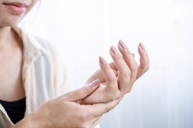 Kadın uyuşukluk ve ellerde ve parmaklarda karıncalanma yaşıyor.