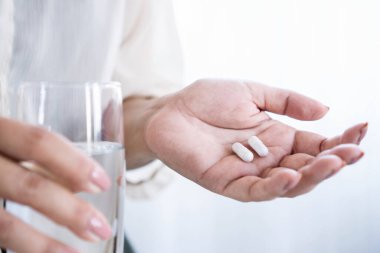 Yakın plan kadın eli, enfeksiyonla savaşmak için probiyotik, prebiyotik, gastrointestinal sorunlar ve ishal sonrası rahatlama alıyor. 