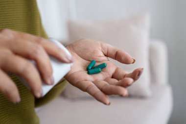 Kadınların el ele tutuşması ve yeşil bitkisel takviyeler alması, örneğin spirulina kapsülleri, sağlık ve sağlık için.