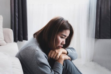 Üzgün Asyalı kadın depresif bozukluk, akıl sağlığı sorunları, anhedonya konsepti yüzünden bir odada tek başına oturuyor. 