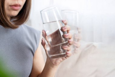 Parkinson hastalığı ya da Temel Sarsıntı Bozukluğu nedeniyle su içerken kadının eli titriyor