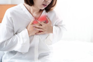 Göğüs ağrısı çeken Asyalı kadın, muhtemelen kalp sorunları, asit reflüsü, anksiyete, kas gerginliği, ya da astım ya da akciğer enfeksiyonu gibi solunum sorunları yüzünden.