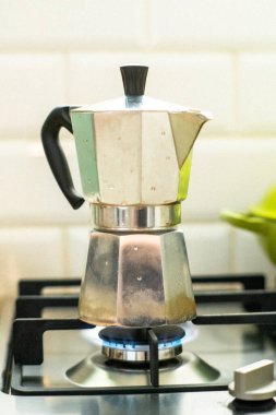 Bu fotoğraf, geleneksel kahve yapımının özünü ev mutfağındaki bir gaz ocağında Mokka Pot ile yakalıyor. Mokka tenceresinin klasik tasarımı ve gaz sobasının mavi alevi görüntüye biraz klasik cazibe katıyor ve onu mükemmel yapıyor.