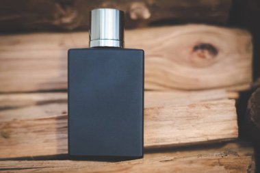 Çarpıcı bir parfüm şişesi. Kırsal bir ahşap arka plana nazikçe yerleştirilmiş.