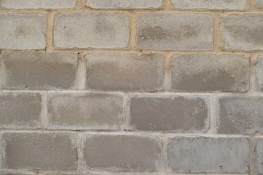 Yıpranmış, kırsal görünümlü, dokulu gri tuğla bir duvar.,