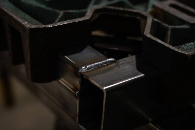 Özel tutuculara tutturulmuş iki kare demir borunun arasına sıcak kaynak.