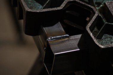 Özel tutuculara tutturulmuş iki kare demir borunun arasına sıcak kaynak.