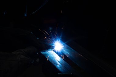 Kaynakçı, mig veya tig kaynakçı, zanaatkar, teknik çelik sanayi, kaynak tabancasından güzel kıvılcımlar, fabrikadaki çelik kaynakçı