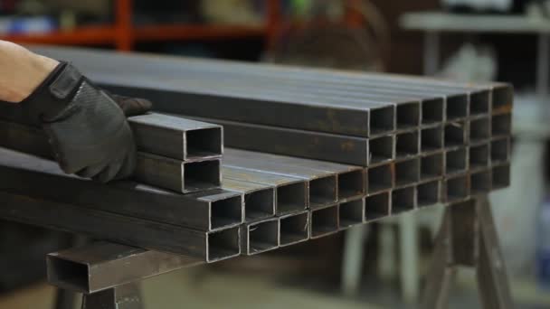 焊工或铁匠从仓库中取出金属制的正方形管材用于工程 — 图库视频影像