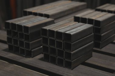 İnşaat malzemeleri ve kaynak işleri için kare metal borular ya da borular yığını. Sektör arkaplanı