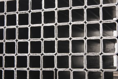 İnşaat malzemeleri ve kaynak işleri için kare metal borular ya da borular yığını. Sektör arkaplanı