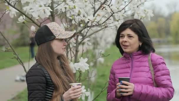 Две Девушки Пьют Кофе Разговаривают Парке — стоковое видео