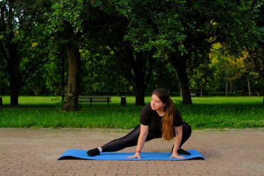 Tombul kız kas esneme egzersizleri yapıyor. Şişkin motive kadın, sağlıklı ve zayıf olmak için esneme egzersizleri yapıyor.