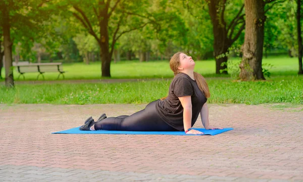 Plump girl doing muscle stretching exercises. Plump motivated woman doing stretching exercises for being healthy and slim