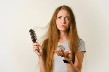 Sağlık hizmetleri şampuanı için saç dökülmesi sorunu olan bir kadın el tarağı.