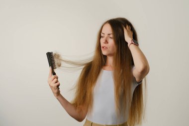 Sağlık hizmetleri şampuanı için saç dökülmesi sorunu olan bir kadın el tarağı.