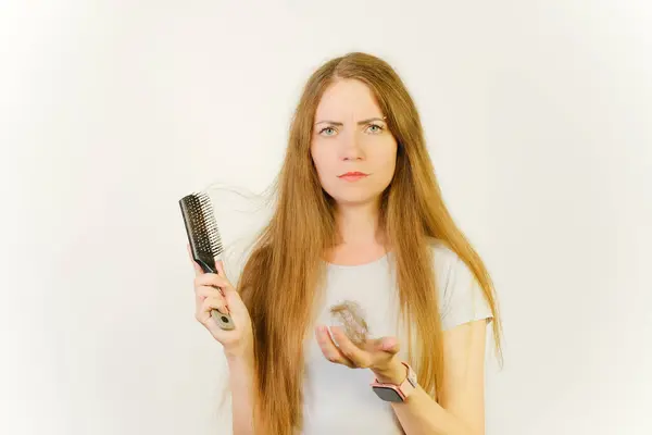 Woman hand holding comb with serious hair loss problem for health care shampoo