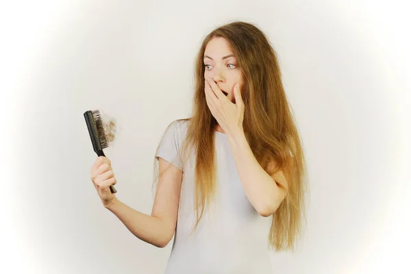 Sağlık hizmetleri şampuanı için saç dökülmesi sorunu olan bir kadın el tarağı.