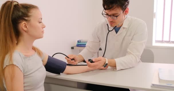 Junger Arzt Misst Den Blutdruck Eines Patienten Einer Klinik Mit — Stockvideo