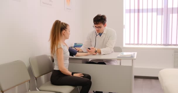 Junger Arzt Misst Den Blutdruck Eines Patienten Einer Klinik Mit — Stockvideo