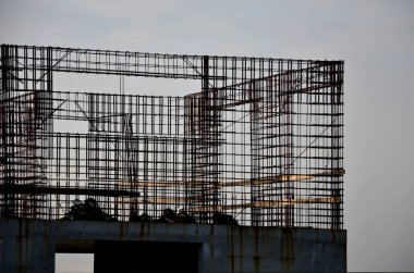 Güçlendirilmiş çelik betondan yapılmış evler depreme dayanıklıdır ve birkaç kat yüksekliğinde olabilirler. Tel örgü örülmüş ve karıştırıcıdan beton dökülmüş, paslı, paslı, dur., 