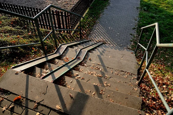 スロープとグレーのコンクリートの階段と車椅子専用の手すりが組み合わされています 都市公園に入るためのセキュリティの趣のある解決策 板金レール — ストック写真