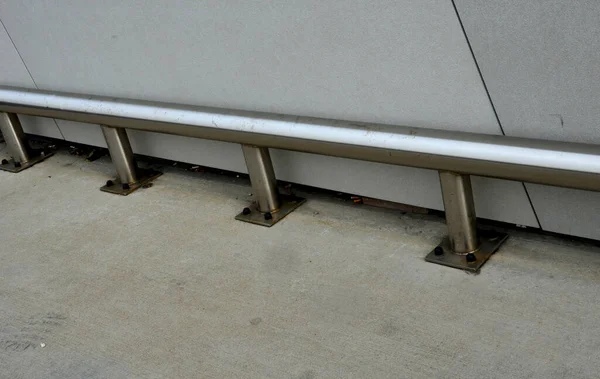 地下ガレージのファサードと柱の周りには ネジで地面に固定されたステンレス製のパイプで作られた金属製のバンパーがあります 4本のネジで床に取り付けられたフレームチューブ — ストック写真