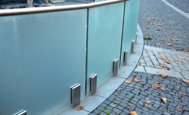 Cam panellerden oluşan lüks bir evin parmaklıkları gri metal paslanmaz çelik panellerle bağlanmış. Sütlü buzlu cam bariyer havadar bir izlenim veriyor. cilalanmış metal kaplama