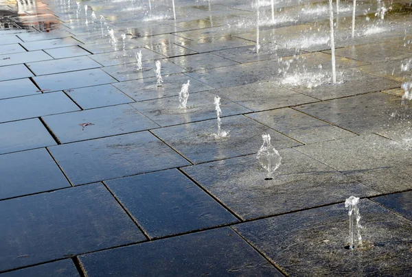 Square Granite Paving Stacked Strip Sidewalk Boy Water Sprays Alternating — Stock Photo, Image