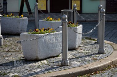 Köy merkezindeki süslü saksılara, menekşeler ve nergislerle süslenmiş beton saksılara. Paskalya yaklaşıyor. Bu yüzden evin girişini süslemek ve park etmek gerekiyor.
