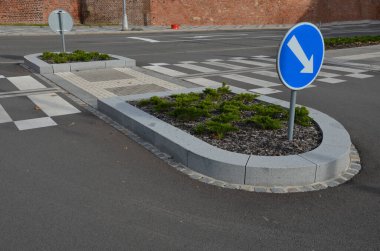 Kavşaktaki kavşakta dikiliyorlar. Düzenli rasterda yatmış ardıçlar. Çiçek tarhı ağaç kabuğu parçalarıyla kaplıdır. Granit kaldırımlar ve yol işaretleri, mozaik, ızgara, kör, tümsekler, adalar, kıvrımlı, kenar