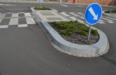 Kavşaktaki kavşakta dikiliyorlar. Düzenli rasterda yatmış ardıçlar. Çiçek tarhı ağaç kabuğu parçalarıyla kaplıdır. Granit kaldırımlar ve yol işaretleri, mozaik, ızgara, kör, tümsekler, adalar, kıvrımlı, kenar