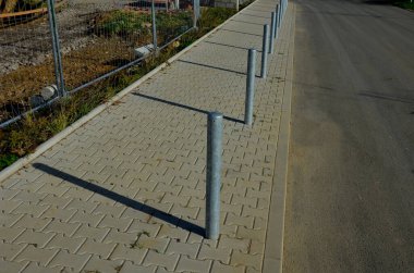 Gri metal kalınlar yaya bölgesindeki yayaları ya da gezinti alanındaki parktaki yayaları korumak için kullanılır. Gri sütunlar araçların kaldırımlara park edilmesini engelliyor