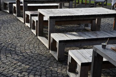 Pergola 'nın altındaki eski ahşap masa. Bahçe evi, köy tarzı. Boyanmamış meşe kalasları, dağlarda kötü havadan korunmak için turistler için aperatif, kürek, kamp, güneş şemsiyesi görevi görür.