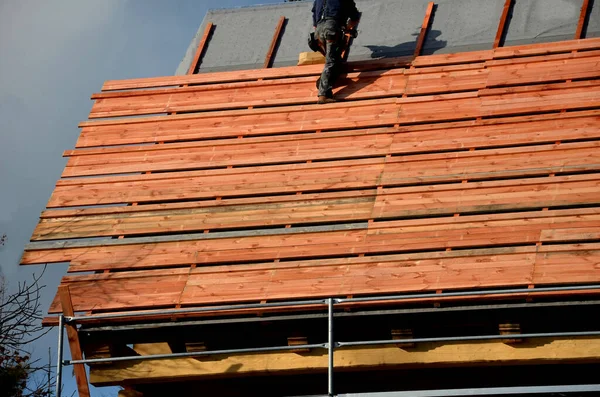 木结构由木梁组装而成 隔热材料为矿棉 墙面为折叠式 墙板为胶合板 屋顶立在山脊上 锤击钉子 — 图库照片