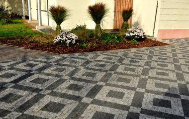 Peyzajlı, süslü çimenler bağlanmış. Kardan ve yağmurdan korunmuş. Zararlı bahçe otları. İple bağlanmış. Mozaik kaldırımlar ev, sarı beyaz, bir demet taş halı.