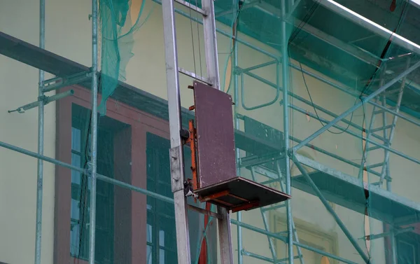 在每个建筑工地上安装倾斜的升降机 运输设备和起重设备 其中一个主要的优点是很容易将材料运送到屋顶 有绞车的弯曲梯子 脚手架 — 图库照片