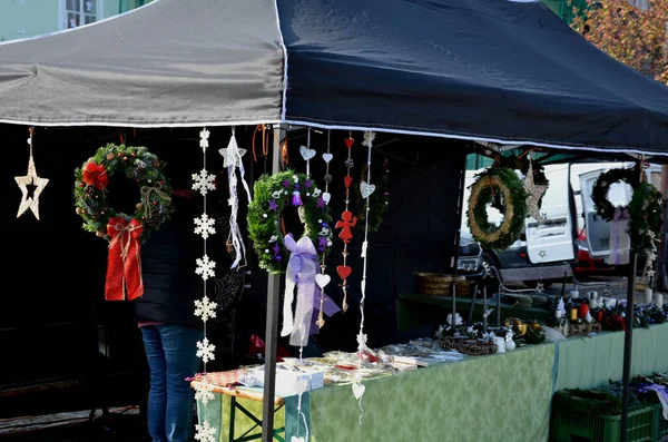 有圣诞装饰品的市场 正方形摊位上的手工艺品 一个帐篷 上面挂着外露的装饰花环供坟墓用 其主题是用苔藓做成的女修道院 彩带和蜡烛 — 图库照片