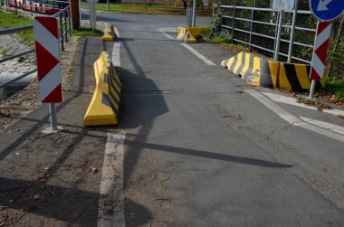 Somut geçici trafik işaretleri. Yolda beton bariyerler var. Yolun bir kısmı kaydığında, trafik tek şeride çıkar. Araç çarpışma şeridi ayırıcısı. levha metal bariyer, vida