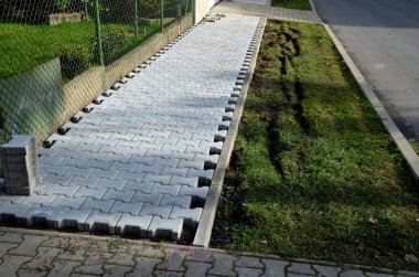 Kaldırımlar arasında beton kaldırım döşemek. Fayans küplerinin kenarları kısaltılmalı ve boşluklara sığmalı. Karşılıklı testere. çakıl döşeme, asfalt döşeme, bisiklet yolu, peyzaj ve toprak işleri