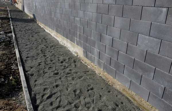 在护栏之间的小巷中铺设混凝土路面 瓷砖立方体的边缘必须缩短 以适应缝隙 往复式锯铺设砂砾 单车径 美化及土方 — 图库照片