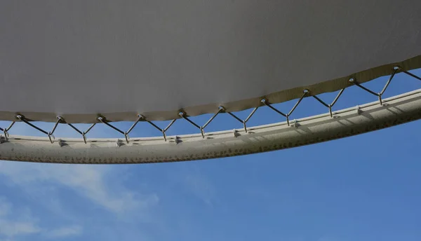 stock image white canvas stretched, shading from the sun and rain over the terrace of the restaurant, on the playground in the kindergarten, on promenade. pergola with pipe, tube gray beams, on white metal steel