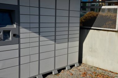 Erkek müşteri, çevrimiçi bir mağazadan mal depolamak için otomatik servis terminali ya da dolap kullanıyor. Kartvizitle veya cep telefonuyla ödeme yaptıktan sonra, kutu açılır ve mallar çıkarılır