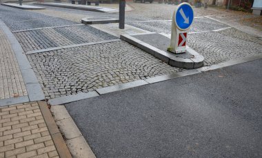 pedestrian crossing with dividing island between lanes. arches with road markings planted with dry-loving flowers along the street. gardening. luxurious stone curbs and paving of the promenade