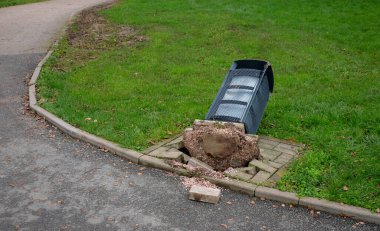 Gri tonlu kablo dizayn yüzeyi olan çöp sepeti sökülmüş. Kazaya arabadaki sarhoş bir sürücü ya da kürekle kar temizleme işi sebep olmuş. düz ve beton