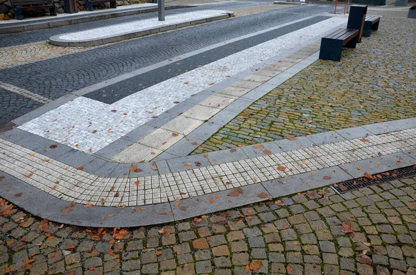 pedestrian crossing with dividing island between lanes. arches with road markings planted with dry-loving flowers along the street. gardening. luxurious stone curbs and paving of the promenade