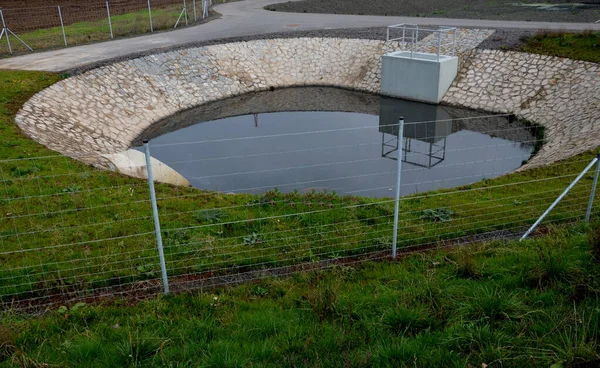 铁丝网后面是一个水闸门 滑块可以设置为一定的水位 它阻碍了排污系统的冲刷 水塘作为在滑雪场上造雪的水源 — 图库照片