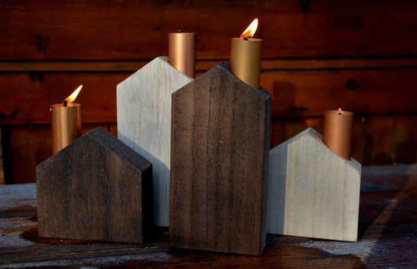 energy crisis of heating with fossil fuels such as coal gas. Schematic wooden houses are Advent decorations. they have copper metal chimneys from which candle flames whip, subsidies, energy savings