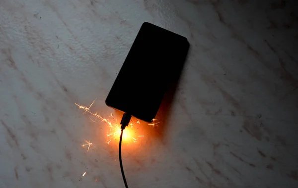 stock image connected to charger in socket. never charge battery overnight, there is risk of battery catching fire, unattended transformer. skin burns when saving property, disconnecting from electric source