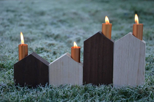 energy crisis of heating with fossil fuels such as coal gas. Schematic wooden houses are Advent decorations. they have copper metal chimneys from which candle flames whip, subsidies, energy savings